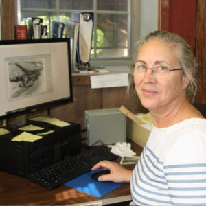 Patti Rockwell inputting photographs into the PastPerfect software on the computer.